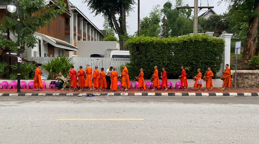 Files de monjos budistes recollint almoines a Luang Prabang, una tradició espiritual imprescindible per descobrir què fer a Luang Prabang
